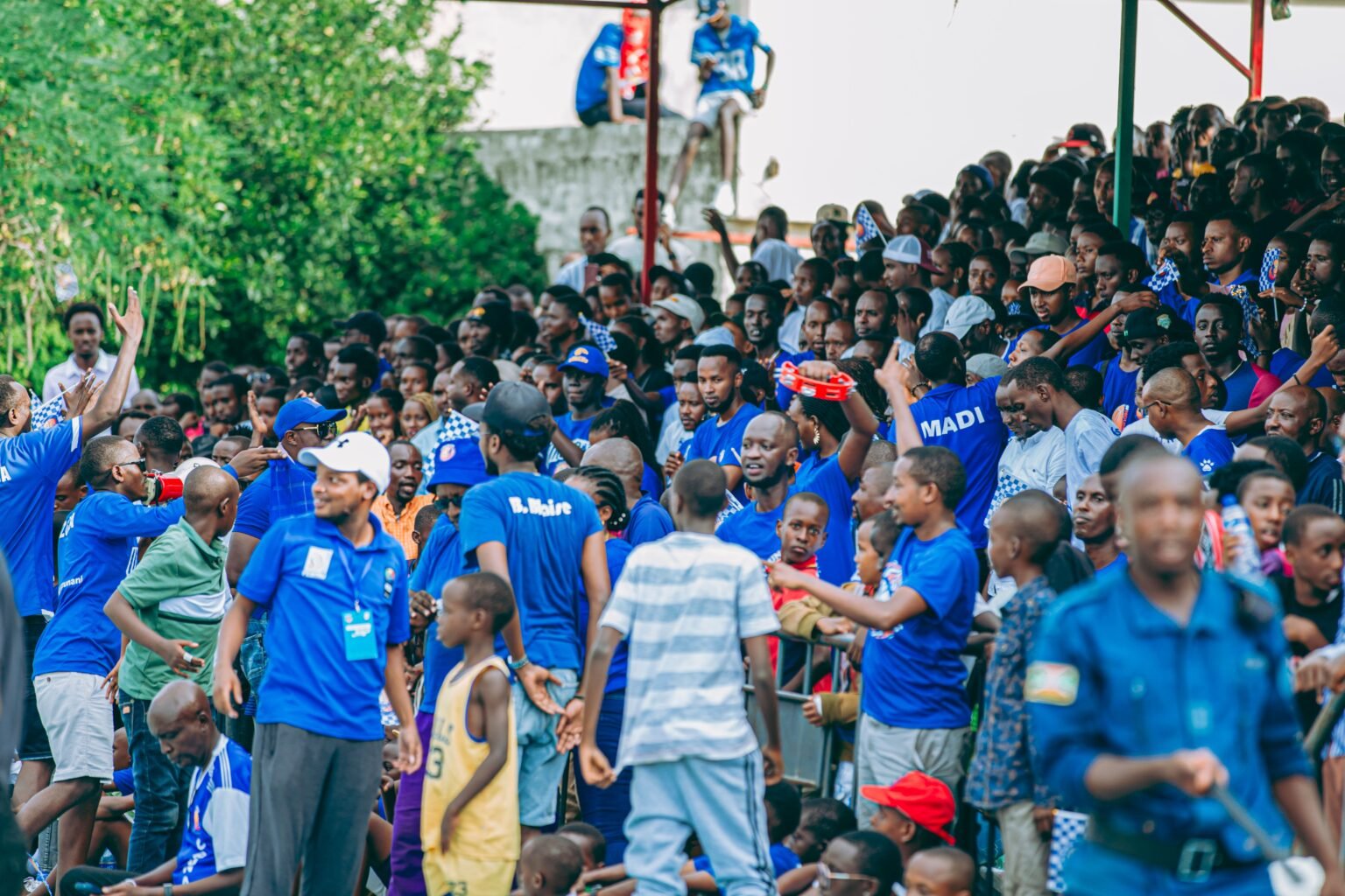 Lively scene of sports fans cheering enthusiastically in an outdoor stadium, showcasing diversity and excitement.